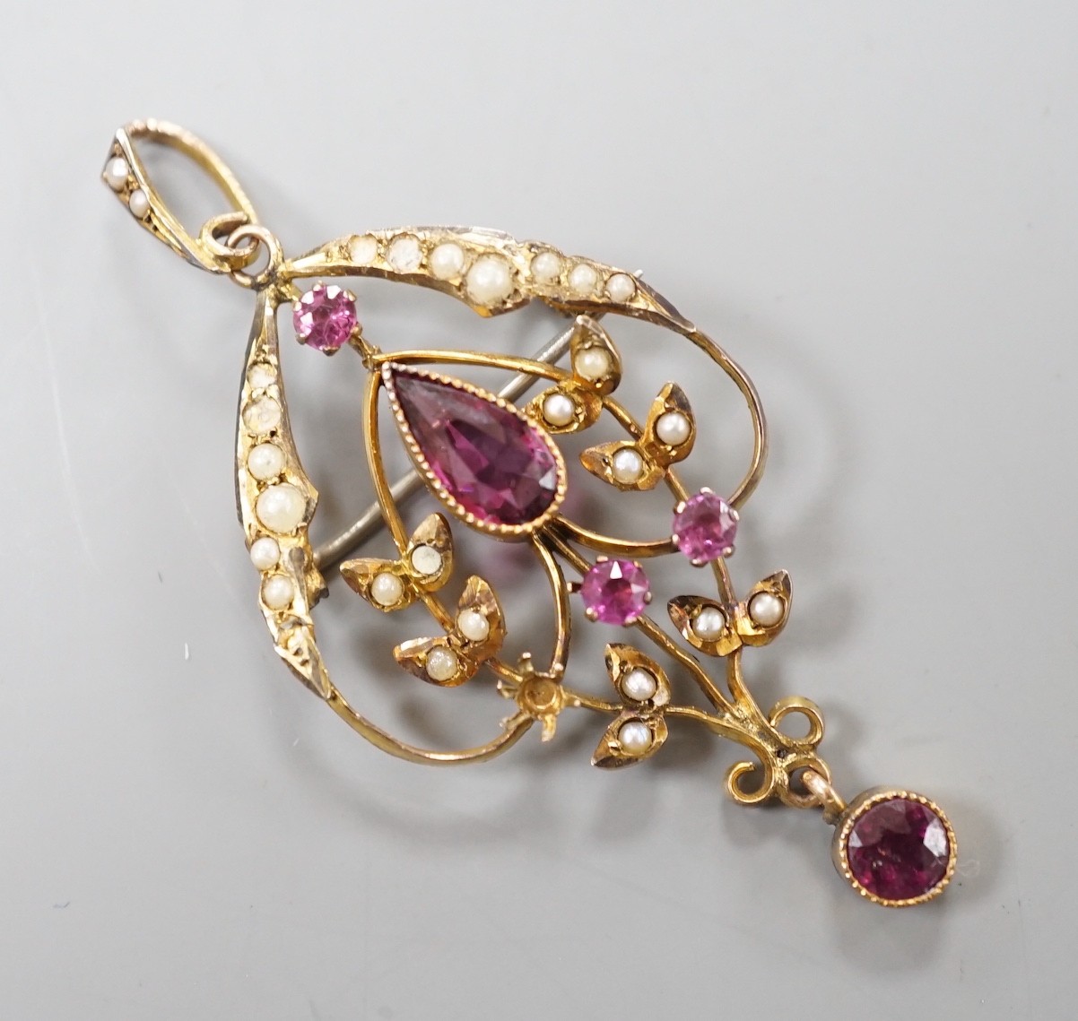 An Edwardian yellow metal, garnet, amethyst? and seed pearl set drop pendant, overall 51mm, gross weight 3.3 grams.